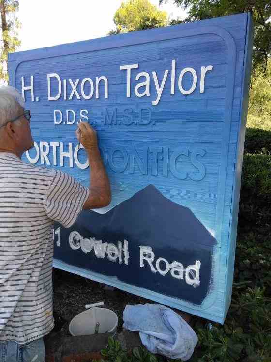 Tim Taylor, the owner of Concord Signs & Banners, showing his paint-covered hand during a sign-making project