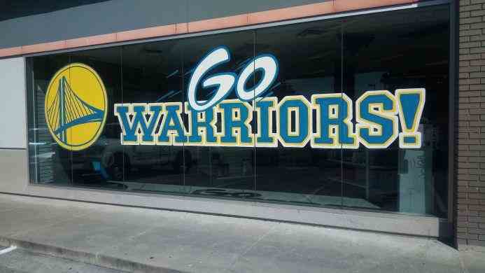 Hand-painted window signage supporting the Golden State Warriors, designed to engage fans and attract attention to businesses in the SF Bay Area