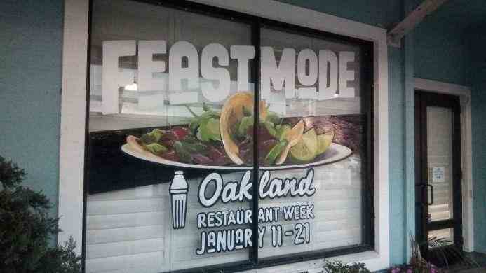 Hand-painted window signage promoting restaurants in the SF Bay Area