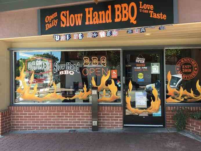 Custom hand-painted window graphics designed to attract attention and promote business visibility, with added neon signage for extra visual impact, helping business owners engage customers from the street