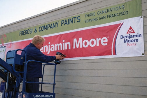 Installer fastening exterior banner to building