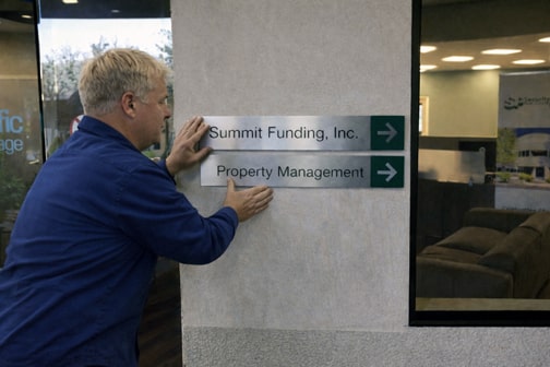 Installer applying interior directional signage
