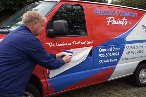 Installer applying vinyl graphics to service van