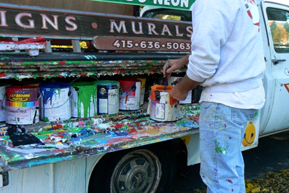 San Francisco mural painter preparing paint for a building exterior