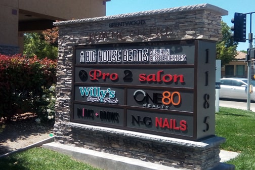 Monument sign listing businesses on a commercial property